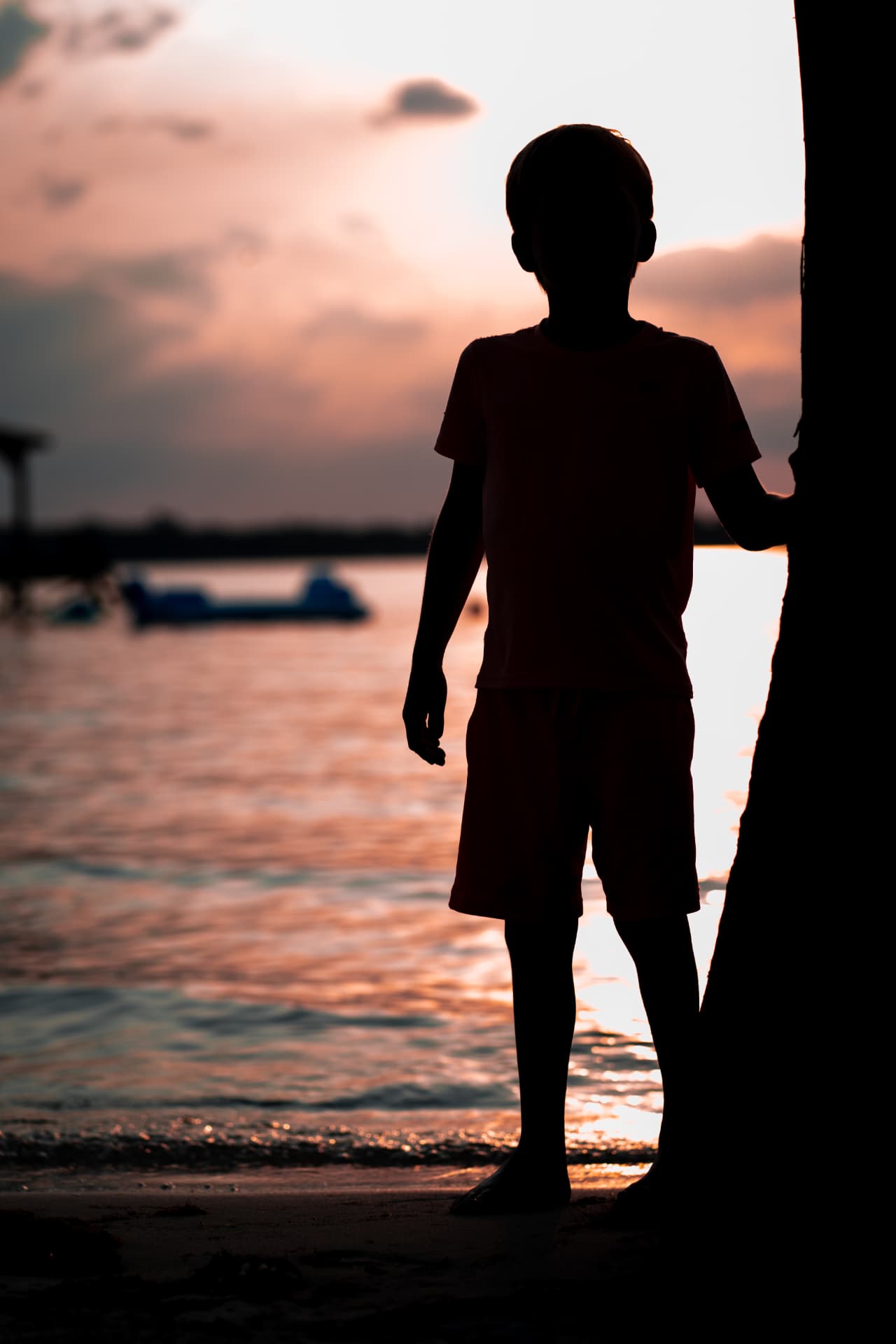 Silhouette of a child at sunset by the water