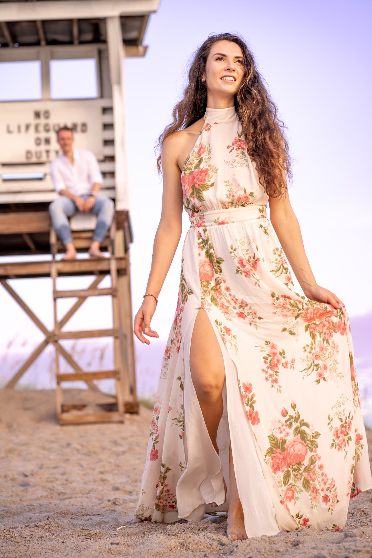 Portrait of a woman in a long floral dress on the beach